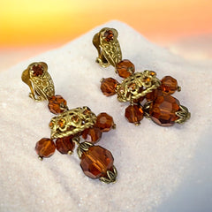 Vintage gold-tone clip-on earrings with honey topaz faceted crystals and ornate filigree dangle design.