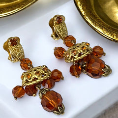 Vintage gold-tone clip-on earrings with honey topaz faceted crystals and ornate filigree dangle design.