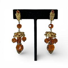 Vintage gold-tone clip-on earrings with honey topaz faceted crystals and ornate filigree dangle design.