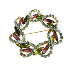 Vintage gold tone wreath brooch with amethyst, peridot, and blue rhinestones, shown in various decorative arrangements.