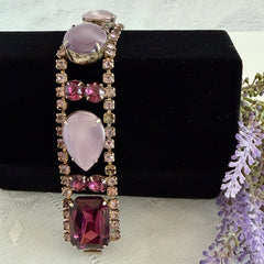 Vintage 1950s bracelet with lavender satin glass cabochons and amethyst rhinestones in prong‑set silver‑tone settings.