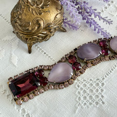 Vintage 1950s bracelet with lavender satin glass cabochons and amethyst rhinestones in prong‑set silver‑tone settings.