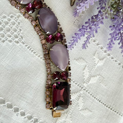 Vintage 1950s bracelet with lavender satin glass cabochons and amethyst rhinestones in prong‑set silver‑tone settings.