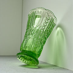 Vintage spring green pressed glass vase with scalloped rim and embossed geometric patterns, shown from various angles to highlight texture and translucence.