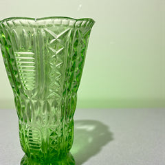 Vintage spring green pressed glass vase with scalloped rim and embossed geometric patterns, shown from various angles to highlight texture and translucence.