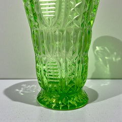 Vintage spring green pressed glass vase with scalloped rim and embossed geometric patterns, shown from various angles to highlight texture and translucence.