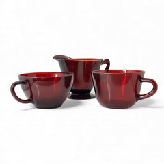 Vintage Anchor Hocking Royal Ruby Red glass creamer and cups set of 3, deep red translucent glass with glossy finish, shown in various angles to highlight design and condition.