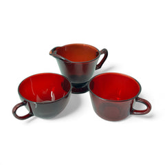 Vintage Anchor Hocking Royal Ruby Red glass creamer and cups set of 3, deep red translucent glass with glossy finish, shown in various angles to highlight design and condition.