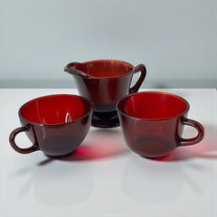 Vintage Anchor Hocking Royal Ruby Red glass creamer and cups set of 3, deep red translucent glass with glossy finish, shown in various angles to highlight design and condition.