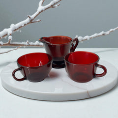 Vintage Anchor Hocking Royal Ruby Red glass creamer and cups set of 3, deep red translucent glass with glossy finish, shown in various angles to highlight design and condition.