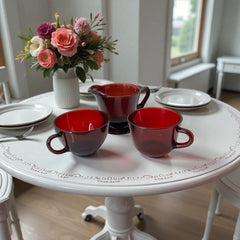 Vintage Anchor Hocking Royal Ruby Red glass creamer and cups set of 3, deep red translucent glass with glossy finish, shown in various angles to highlight design and condition.