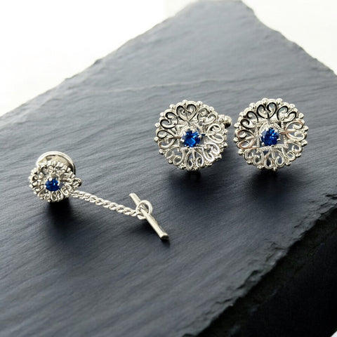 Vintage Anson men’s jewelry set featuring silver-tone round cufflinks and matching tie tack with blue rhinestones and openwork filigree design; presented in original moss green velvet-lined box, all pieces signed and in excellent condition.