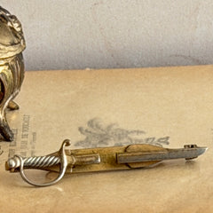 Vintage Anson gold‑tone sword tie clip with silver‑tone grip and engraved details