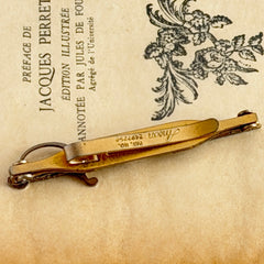 Vintage Anson gold‑tone sword tie clip with silver‑tone grip and engraved details