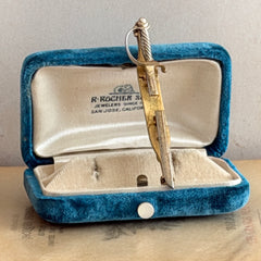 Vintage Anson gold‑tone sword tie clip with silver‑tone grip and engraved details