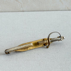 Vintage Anson gold‑tone sword tie clip with silver‑tone grip and engraved details