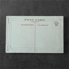 Antique 1910s embossed postcard featuring a snowy path with a person and child walking, framed by gilded orange-brown border; message reads “All Good Wishes for the New Year.