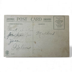 Antique 1912 New Year postcard featuring embossed deer in snowy forest with pinecones and gold gilt, muted lavender background, greeting “A Happy New Year” in capital letters, very good condition with minimal corner wear.