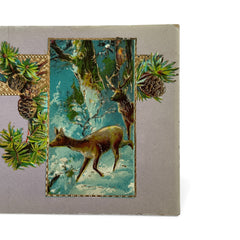 Antique 1912 New Year postcard featuring embossed deer in snowy forest with pinecones and gold gilt, muted lavender background, greeting “A Happy New Year” in capital letters, very good condition with minimal corner wear.