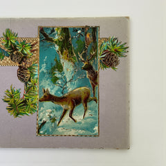 Antique 1912 New Year postcard featuring embossed deer in snowy forest with pinecones and gold gilt, muted lavender background, greeting “A Happy New Year” in capital letters, very good condition with minimal corner wear.