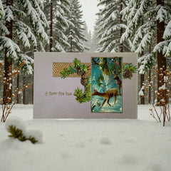 Antique 1912 New Year postcard featuring embossed deer in snowy forest with pinecones and gold gilt, muted lavender background, greeting “A Happy New Year” in capital letters, very good condition with minimal corner wear.