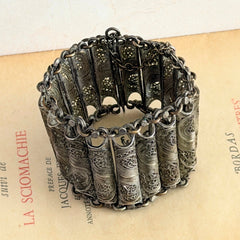 Antique Balkan cannetille silver bracelet with ornate filigree links, side chains, and a long pin clasp, shown in its natural patina.