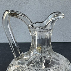 Antique pressed clear glass cruet with diamond pattern and rounded base.
