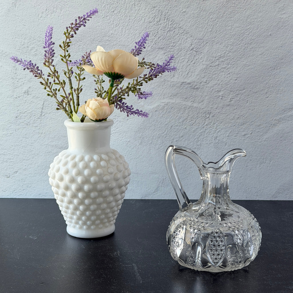 Antique pressed clear glass cruet with diamond pattern and rounded base.