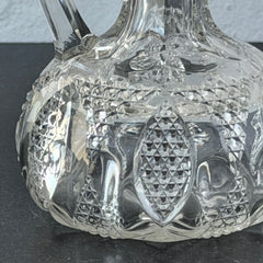 Antique pressed clear glass cruet with diamond pattern and rounded base.