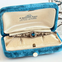 Antique French silver bar brooch with an oval Swiss‑blue topaz at the center, framed by clear stones and delicate openwork detailing.