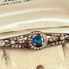 Antique French silver bar brooch with an oval Swiss‑blue topaz at the center, framed by clear stones and delicate openwork detailing.