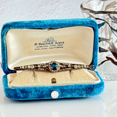 Antique French silver bar brooch with an oval Swiss‑blue topaz at the center, framed by clear stones and delicate openwork detailing.