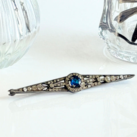 Antique French silver bar brooch with an oval Swiss‑blue topaz at the center, framed by clear stones and delicate openwork detailing.