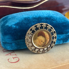 Antique Victorian portrait brooch with lithograph miniature, brass fleur‑de‑lys frame, and celluloid cover.