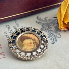 Antique Victorian portrait brooch with lithograph miniature, brass fleur‑de‑lys frame, and celluloid cover.