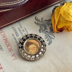 Antique Victorian portrait brooch with lithograph miniature, brass fleur‑de‑lys frame, and celluloid cover.