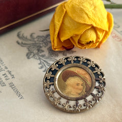 Antique Victorian portrait brooch with lithograph miniature, brass fleur‑de‑lys frame, and celluloid cover.