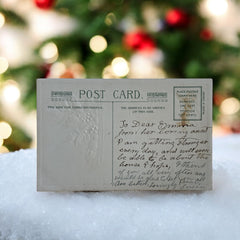 Antique embossed German New Year postcard from the 1910s featuring an open book with snowy countryside illustration, festive holly sprig, and ornate greeting text.
