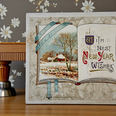 Antique embossed German New Year postcard from the 1910s featuring an open book with snowy countryside illustration, festive holly sprig, and ornate greeting text.