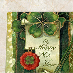 Antique 1913 New Year postcard featuring embossed four-leaf clovers, gilded scroll with greeting, and red seal motif; preserved message on reverse, marked Made in Saxony.