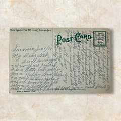 Antique 1913 New Year postcard featuring embossed four-leaf clovers, gilded scroll with greeting, and red seal motif; preserved message on reverse, marked Made in Saxony.