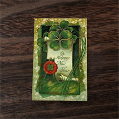 Antique 1913 New Year postcard featuring embossed four-leaf clovers, gilded scroll with greeting, and red seal motif; preserved message on reverse, marked Made in Saxony.