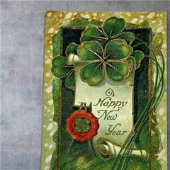 Antique 1913 New Year postcard featuring embossed four-leaf clovers, gilded scroll with greeting, and red seal motif; preserved message on reverse, marked Made in Saxony.