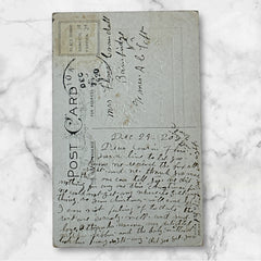 Embossed vintage New Year postcard with holly leaves and berries framing a gold “JAN 1” calendar; “New Year Greetings” printed in gold below. Made by Stechler Litho Co., postmarked December 1920.