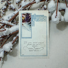 Printed vintage New Year postcard with a snowy forest illustration and ornate blue scrollwork; greeting reads “To you and yours from me and mine — a VERY HAPPY NEW YEAR.” Postmarked December 1923.