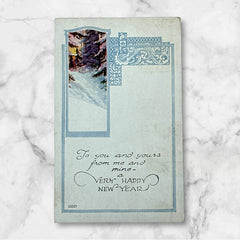 Printed vintage New Year postcard with a snowy forest illustration and ornate blue scrollwork; greeting reads “To you and yours from me and mine — a VERY HAPPY NEW YEAR.” Postmarked December 1923.