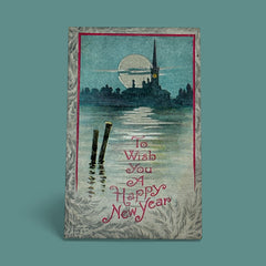Antique 1910s New Year postcard showing a silver moonlit church and town skyline reflected on a river, with ornate red lettering “To Wish You A Happy New Year” and handwritten family message on reverse, very good condition with light corner wear.