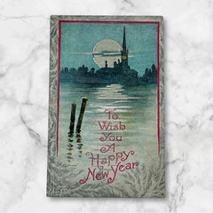 Antique 1910s New Year postcard showing a silver moonlit church and town skyline reflected on a river, with ornate red lettering “To Wish You A Happy New Year” and handwritten family message on reverse, very good condition with light corner wear.