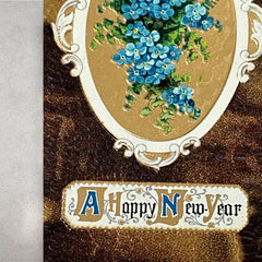 Antique 1910s New Year postcard featuring embossed blue forget-me-not flowers in a gold-gilded oval frame, set against a textured brown background resembling crocodile skin; elegant and well-preserved with handwritten 1913 message on reverse.