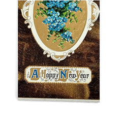 Antique 1910s New Year postcard featuring embossed blue forget-me-not flowers in a gold-gilded oval frame, set against a textured brown background resembling crocodile skin; elegant and well-preserved with handwritten 1913 message on reverse.